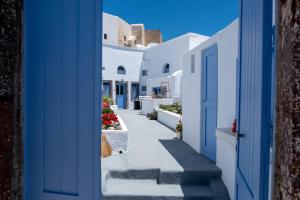 皮尔戈斯Labyrinth Traditional Houses的白色建筑的走廊,有蓝色的门