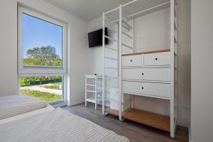 特伦特Ferienhaus Rügen-Relax的卧室配有白色双层床和窗户。
