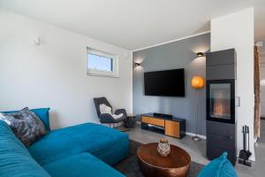 特伦特Ferienhaus Rügen-Relax的客厅配有蓝色的沙发和电视