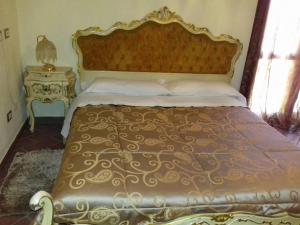 卢戈Ca' Bianca的一间卧室配有一张大床和金色床罩