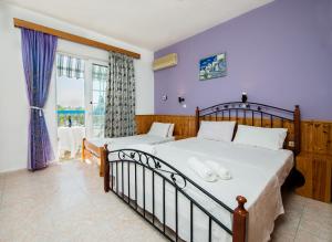 阿彻奇洛斯Poseidon Apartment的一间卧室设有两张床和大窗户