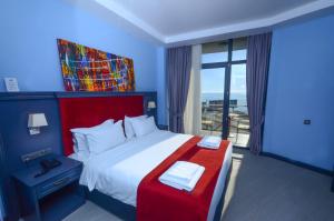 巴统Batumi Palm Hotel的一间卧室设有一张大床和一个大窗户