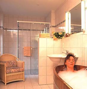 弗洛托森克尔特艾克莫尔兰德酒店的妇女在浴室的浴缸里躺着