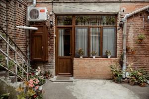 第比利斯Tbilisi Apartment的砖砌建筑,有门,有盆栽植物