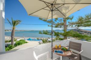 纳克索乔拉Prestige on the beach的一张桌子和椅子,配有遮阳伞和海滩