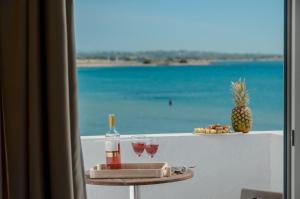 纳克索乔拉Prestige on the beach的一张带酒杯的桌子,享有海滩美景