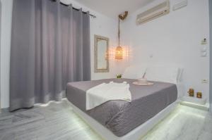 纳克索乔拉Prestige on the beach的白色卧室,配有一张带灰色毯子的床