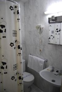 马德里阿斯图里亚珍珠旅馆的浴室设有卫生间和挂有奶牛的浴帘。