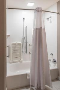 安哥拉Wingate by Wyndham Angola的带淋浴、浴缸和淋浴帘的浴室