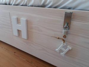 锡尼什Origens Hostel的床上挂着字母h的标志