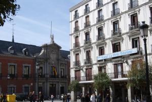 马德里阿斯图里亚珍珠旅馆的一座白色的大建筑,上面有街道标志