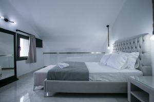 圣尼古拉奥斯Anemos Luxury Apartments的白色的卧室设有一张大床和一个窗户