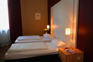 美因河畔法兰克福库鲁布斯酒店的酒店客房设有两张床和一张桌子。