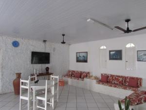 阿尔科巴萨Pousada Pé de Caju的客厅配有沙发和墙上的电视