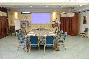 维韦罗内滨海酒店的一间会议室,配有桌椅和投影屏幕