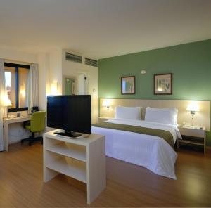 萨尔瓦多Rede Concept - Hotel Salvador的一间卧室配有一张大床和电视