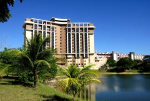 萨尔瓦多Rede Concept - Hotel Salvador的一座棕榈树环绕的湖前大建筑