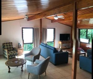 拉罗汤加Pacific views, tranquil location, extra large home, Navy House 1的客厅配有蓝色的沙发和椅子