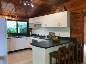 拉罗汤加Pacific views, tranquil location, extra large home, Navy House 1的厨房配有白色橱柜和黑色台面