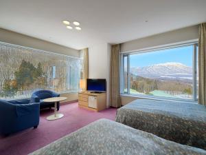 雫石町雫石王子酒店的酒店客房设有两张床和大窗户。