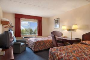 曼切斯特曼彻斯特机场速8酒店的酒店客房设有两张床、一张桌子和一台电视。