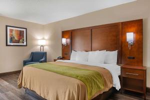 尤利Comfort Inn Yulee - Fernandina Beach的酒店客房带大床和蓝椅