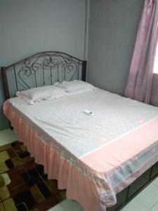 PakaBonda Guesthouse II的一张带白色床单和粉色毯子的床