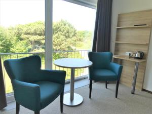 卡兰茨奥赫霍恩酒店的客房设有2把椅子和一张桌子以及一个阳台。