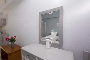 阿凯松Theodora Studios的浴室设有镜子和白色水槽