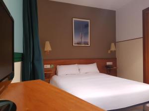 巴塞罗那埃尔哈迪酒店的一间卧室配有一张床和一张书桌及电视
