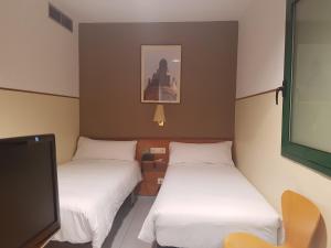 巴塞罗那埃尔哈迪酒店的客房设有两张床和一台平面电视。