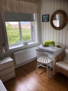 GeitaskardFerðaþjónustan Geitaskarði的客房设有桌子、椅子和窗户。