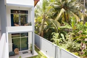 希克杜沃Alvas house的享有棕榈树房屋景致的阳台
