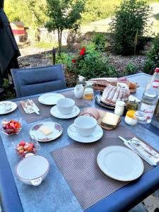 维桑堡Aux vignes的一张蓝色桌子,上面有白色的盘子和食物
