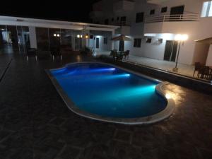 古鲁皮Di Napoli Plaza Hotel的夜间游泳池,灯光蓝色