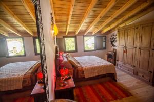 阿拉哈尔Casa con encanto en Alájar的客房设有两张床铺、木制天花板和窗户。