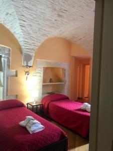 马丁纳弗兰卡B&B Nel Centro Storico的一间设有两张红色床单的床的房间