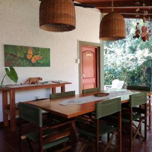 伊瓜苏港Oasis Bed and Breakfast的一间带木桌和绿色椅子的用餐室