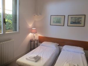 蓬塔阿拉Appartamenti Boboli的一间卧室设有两张床、一盏灯和一扇窗户。