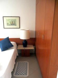 蓬塔阿拉Appartamenti Boboli的一间卧室配有一张床和一张带台灯的桌子