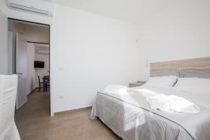 托雷圣乔万尼乌Villa Milù的一间带白色床的卧室和一间用餐室