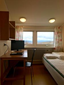 基律纳STF玛丽丰滕斯福利斯科拉酒店的一间卧室配有一张桌子、一台电脑和一张床