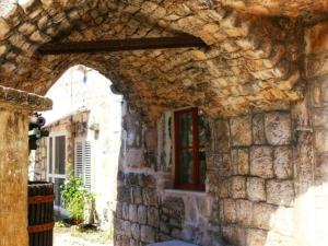 拉斯托伏Accommodation Santor的一座石头建筑,设有窗户和拱门