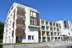 巴拉通雷勒Lido Riviéra, Relux Apartman Balatonlelle的白色的建筑,旁边设有阳台