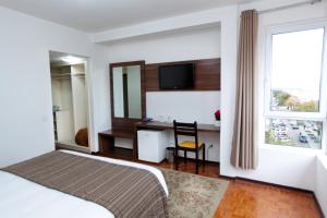 巴热奥比诺巴吉酒店的一间卧室配有一张床、一张书桌和一个窗户。