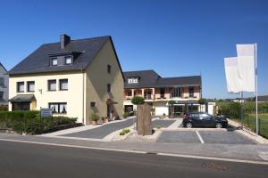 特里滕海姆Moselweingut & Gästehaus Hubertushof的车道上停放一辆汽车的白色房子