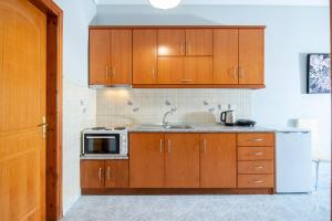 锡基亚family house nikos 2的一间带木制橱柜和微波炉的厨房