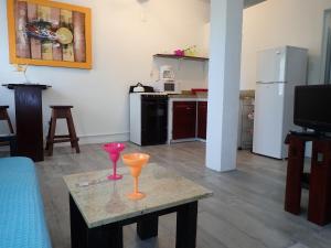 玛雅湾Simberts Apartments的客厅配有桌子和两杯酒杯