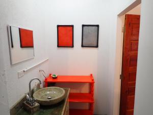 玛雅湾Simberts Apartments的浴室设有红色水槽和红色架子