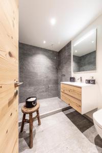 达沃斯Unique Alpic style apartment in the heart of Davos的一间带水槽、卫生间和凳子的浴室